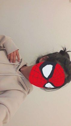 a woman wearing a spider - man mask with her head sticking out from the back