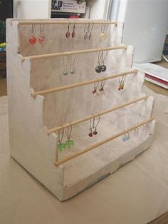 a set of six pairs of earrings hanging on a wooden rack