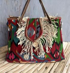 Add a unique piece to your winter outfit style with a bohemian carry-all large tote with tassels colored with natural root dyes in a hand-woven traditional wool rug. Handle and upper part are made of genuine leather. You can remove the strap according to your daily style. You can use this purse as a shoulder bag or handbag. Shoulder strap is adjustable. Suitable for using as a crossbody bag. Together with the bag, we will send two straps, one in real leather and one in guitar strap. You can use Bohemian Natural Hobo Bag With Double Handle, Bohemian Handmade Travel Shoulder Bag, Bohemian Bags For Everyday Use, Bohemian Brown Hobo Bag, Multicolor Bohemian Shoulder Bag For Travel, Bohemian Natural Shoulder Bag With Double Handle, Bohemian Natural Color Bags With Double Handle, Bohemian Rectangular Hobo Bag, Bohemian Double Handle Natural Bag