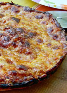 a pizza sitting on top of a wooden table