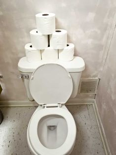 a toilet with several rolls of toilet paper on top