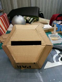 an open cardboard box sitting on top of a table next to other items and tools