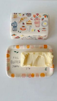 two pieces of butter sitting on top of a white tablecloth covered tray with designs