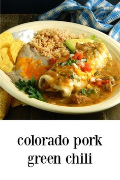 a white plate topped with meat and rice covered in green chile sauce next to tortilla chips