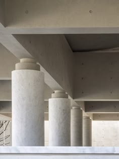 the columns are all lined up against the concrete wall in this modern architectural design building