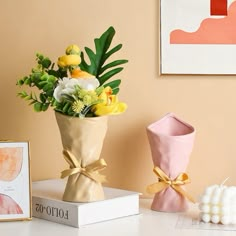 a bouquet of flowers in a vase sitting on a table next to two small candles