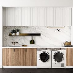 a washer and dryer in a kitchen with marble counter tops on the wall