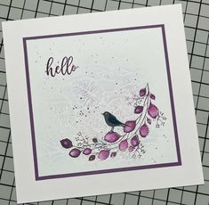 a card with a bird on it and the words hello written in black ink, sitting on top of a table