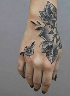 a woman's hand with a flower tattoo on it