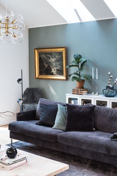 a living room filled with furniture and a painting on the wall