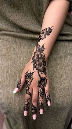 a woman's hand with hennap and flowers on her left arm, showing the