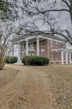 a large red brick house surrounded by trees