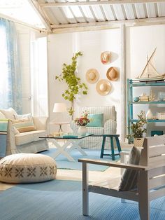 a living room filled with lots of furniture and decor on top of blue rugs