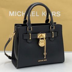 Michael Kors Hamilton Small Satchel Shoulder Crossbody Bag Pebbled Leather Michael Kors Logo At Front Zip Top Closure Gold Toned Hardware Black Color Mk Key & Lock On Front Custom Mk Fabric Lining 1 Slip-In Pockets 1 Zipper Pocket 10" (L) X 8"(H) X 4"(D) Strap: 4", 18"- 24" Very Clean, Smoke-Free And Pet-Free Environment Classic Crossbody Bag With Lock, Designer Crossbody Bag With Lock, Black Top Handle Satchel With Lock, Designer Black Shoulder Bag With Lock, Black Travel Bag With Lock, Black Formal Bags With Lock, Black Formal Bag With Lock, Michael Kors Bags With Metal Hardware For Daily Use, Black Top Handle Shoulder Bag With Lock