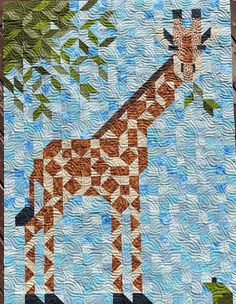 a quilted giraffe standing next to a tree