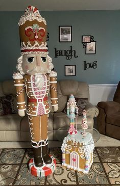 a large nutcracker standing next to a small gingerbread man on a table