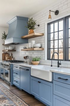 a kitchen with blue cabinets and white tile backsplash, an open window over the sink