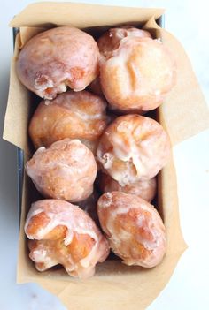 a box filled with glazed donuts sitting on top of a table