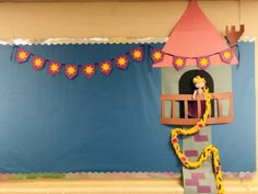 there is a castle made out of paper and some decorations on the wall behind it