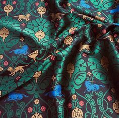 an image of a blue and green fabric with animals on it's side,