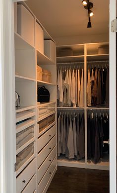 an organized closet with white drawers and shelves