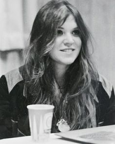 a woman sitting at a table with a coffee cup