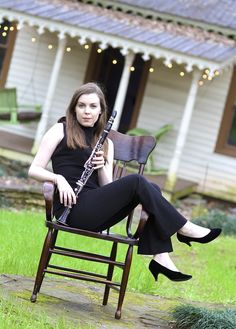 a woman sitting in a chair holding a flute