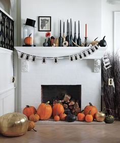 a fireplace decorated for halloween with pumpkins, candles and decorations on the mantel