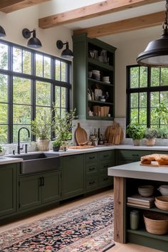 a kitchen with green cabinets and lots of windows