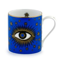 a blue and gold coffee cup with an all seeing eye on the front, surrounded by stars