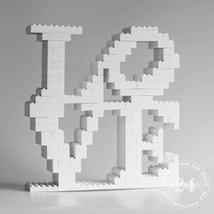 a white sculpture made out of legos on top of a table next to a black and white photo