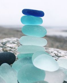 a stack of sea glass sitting on top of a rock