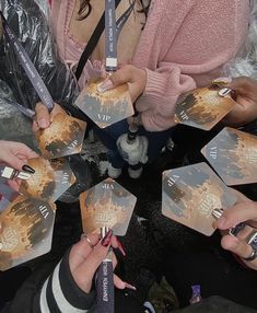 a group of people sitting around each other holding up small cards with writing on them