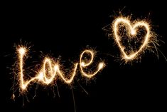 the word love spelled out with sparklers