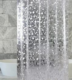 a shower curtain with white flowers on it in front of a bathtub and sink