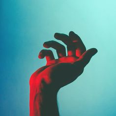 a person's hand reaching up into the sky