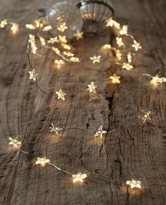 the string lights are hanging on the wooden table