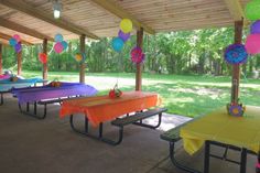 an outdoor picnic area with tables and colorful decorations