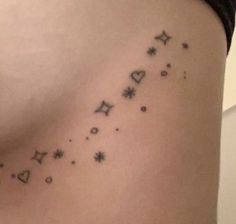 a woman's stomach with stars and moon tattoos on her side ribcage