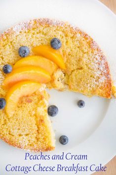 a piece of peaches and cream cottage cheese breakfast cake on a white plate with blueberries