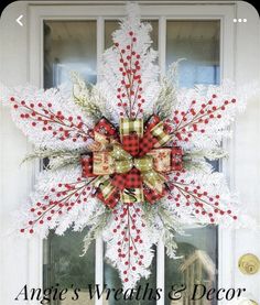 a snowflake wreath on the front door of a house with words angel's wreaths and decor above it