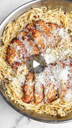 chicken parmesan in a skillet on a marble counter top, with the pasta being cooked