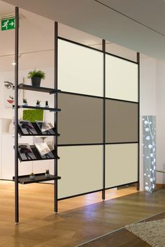 a room divider with shelves and plants in it