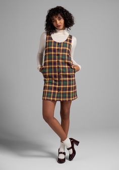 In an exclusive plaid print made up of rich and earthy tones of mustard, hunter green, and burgundy, you can’t get more retro than this fully-lined shift dress from our ModCloth namesake label ! Made from a stretchy woven fabric, this sleeveless shift dress boasts front button-up closure, a curved V-neckline and a fabulous flared hemline at the knee-length skirt. The classic relaxed silhouette is perfect from adding warm layers in the colder months, and this easy A-line looks fresh and playful w 60s Look Outfits, 90s Fall Outfits Plus Size, Casual 60s Outfits For Women, Modest 80s Fashion, 1969 Fashion Women, Playful Outfits For Women, Mod Dress Outfit, 80s Dress Outfit, Modern 60s Outfits