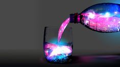 a bottle pouring water into a glass filled with pink and blue liquid that reads me tome