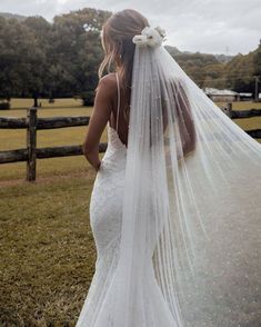 a woman in a wedding dress with a veil over her head