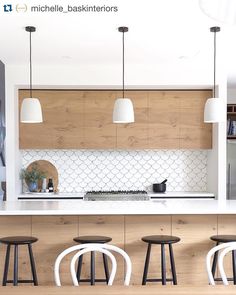 a kitchen with white counter tops and stools