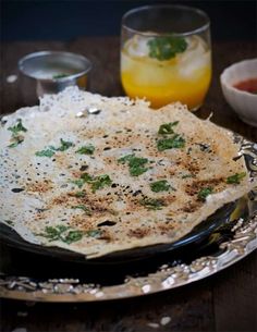 an omelet on a plate next to some drinks