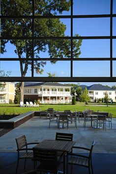 tables and chairs are set up outside in front of the large windows on the building