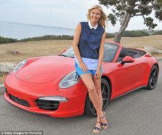 a woman leaning on the hood of a red sports car